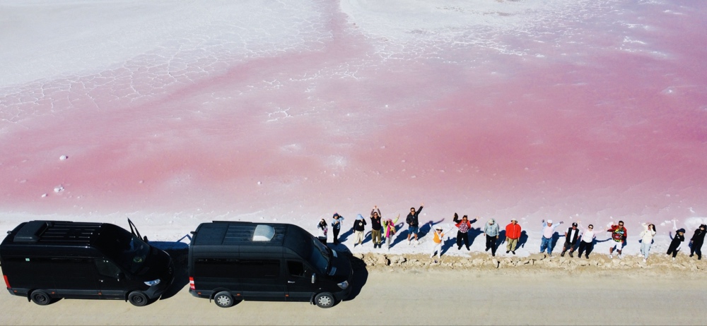 南澳粉红湖 (Pink Lake) 边停放的两辆黑色奔驰商务保障车及东西大穿越团队合影。