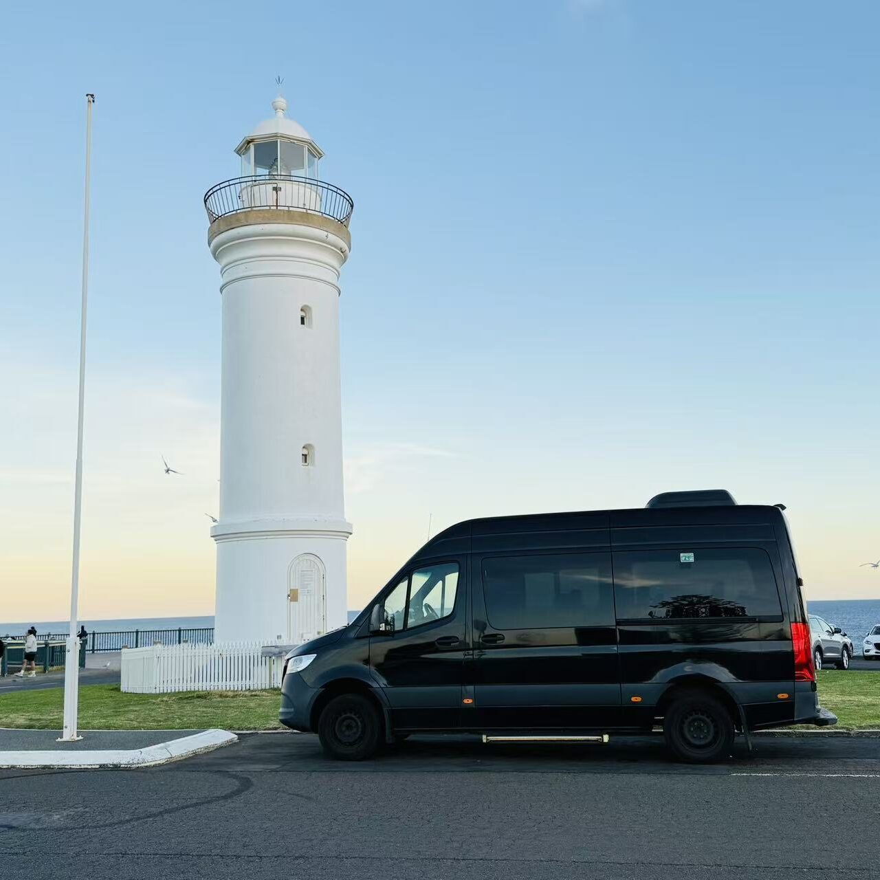 Mercedes Sprinter parked near a lighthouse during a scenic coastal road trip in Australia