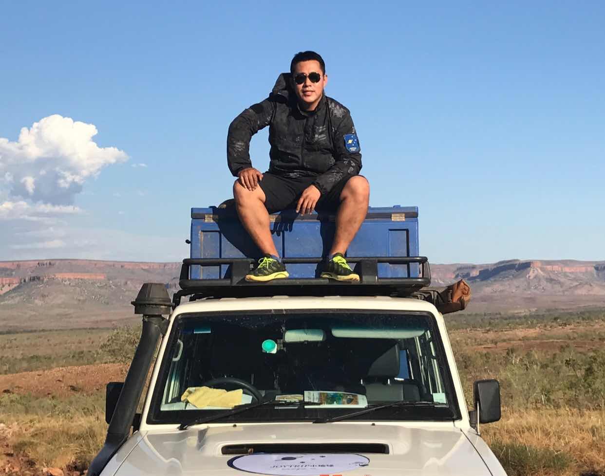 Leo, founder of Leo Australia, on top of a 4WD vehicle in the Australian outback during a guided road tripLeo Australia 创始人 Leo 在澳洲内陆荒野越野车顶上的实拍照片，体现澳洲公路旅行与户外带队经验