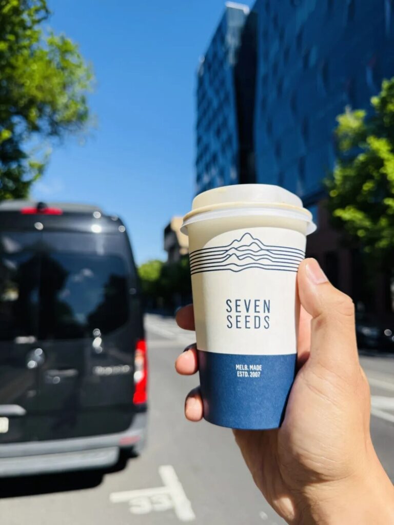 Holding Seven Seeds specialty coffee cup on Melbourne street Carlton Victoria Australia