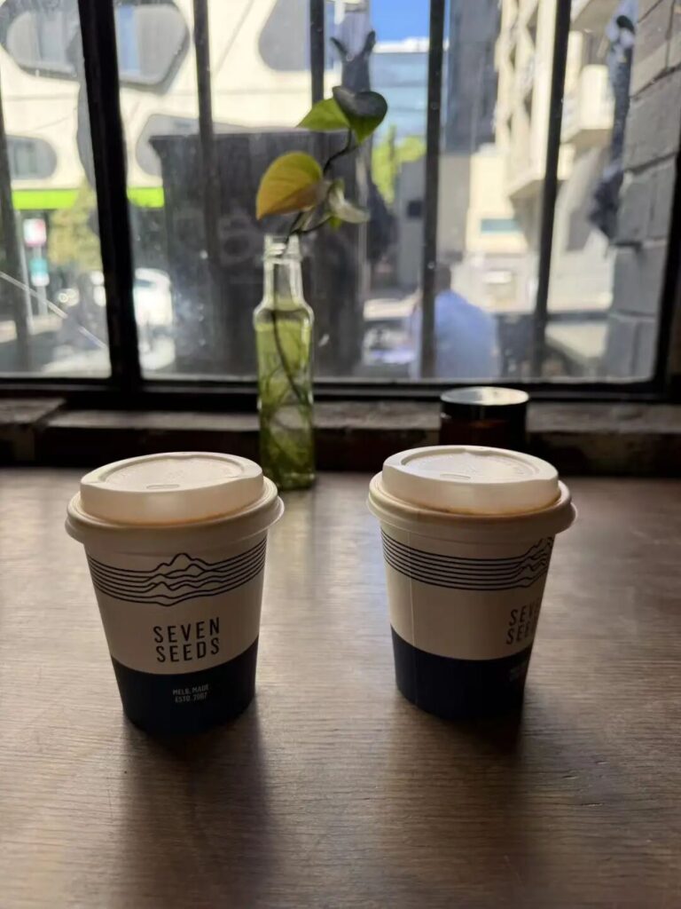 Two Melbourne Flat White coffees by the window at Seven Seeds Coffee Roasters Carlton