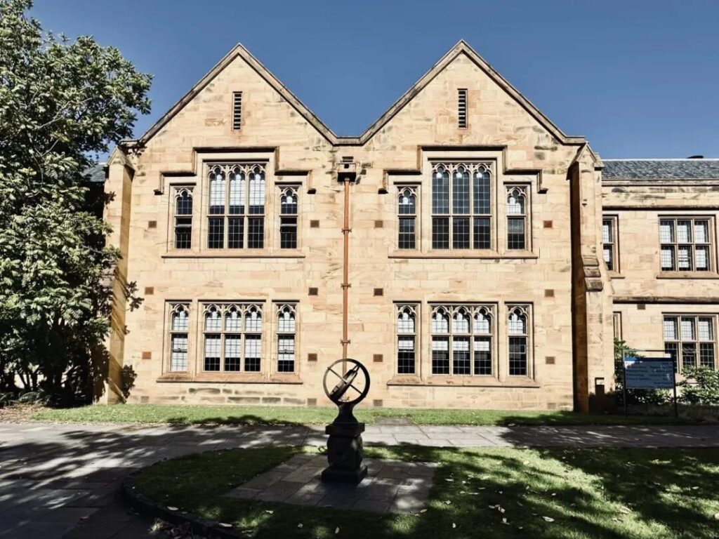 Historic sandstone Old Arts Building with sundial sculpture at University of Melbourne Parkville