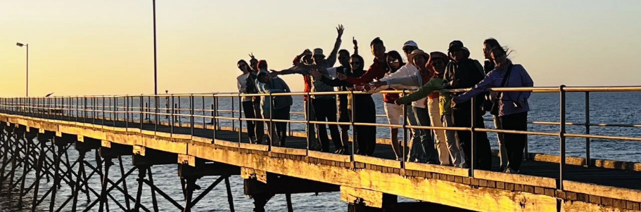 Leo Australia澳洲东西大穿越客户好评页面Banner，塞杜纳码头Ceduna Jetty夕阳下团队成员欢乐合影，真实客户评价见证专业华人深度旅行领队服务