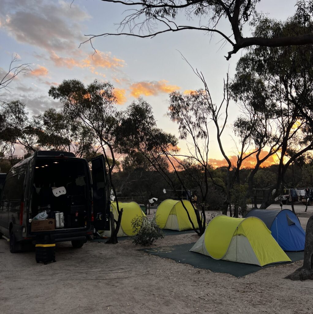 澳洲内陆Outback露营日落场景，房车与帐篷在金黄暮色中，Leo Australia经典野外住宿体验