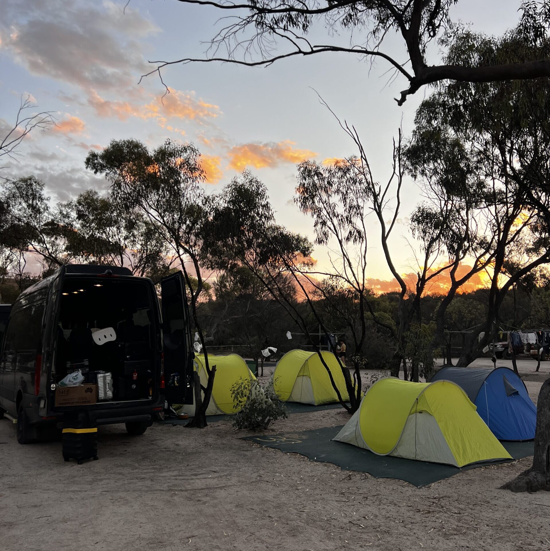 澳洲内陆Outback露营日落场景，房车与帐篷在金黄暮色中，Leo Australia经典野外住宿体验