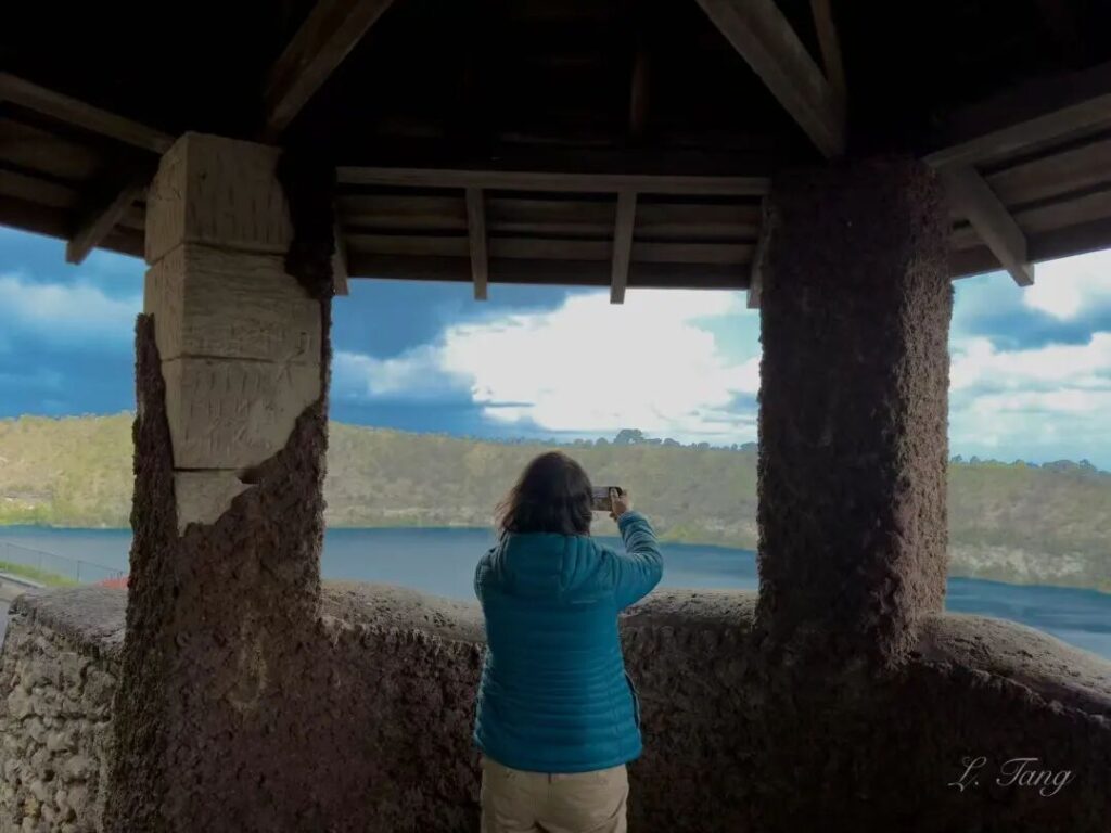 游客在大蓝湖观景塔内用手机拍照，南澳火山湖观景台的独特框架视角