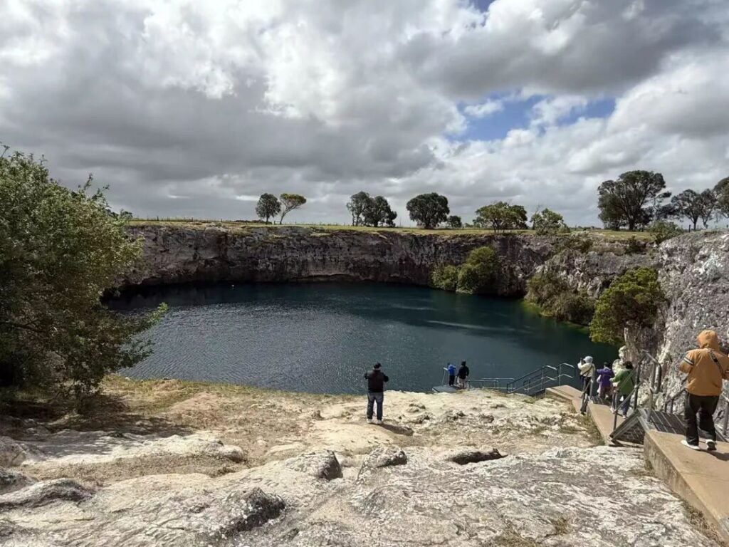 游客在小蓝湖观景台俯瞰火山湖，南澳自然景点打卡，湖水幽深湛蓝