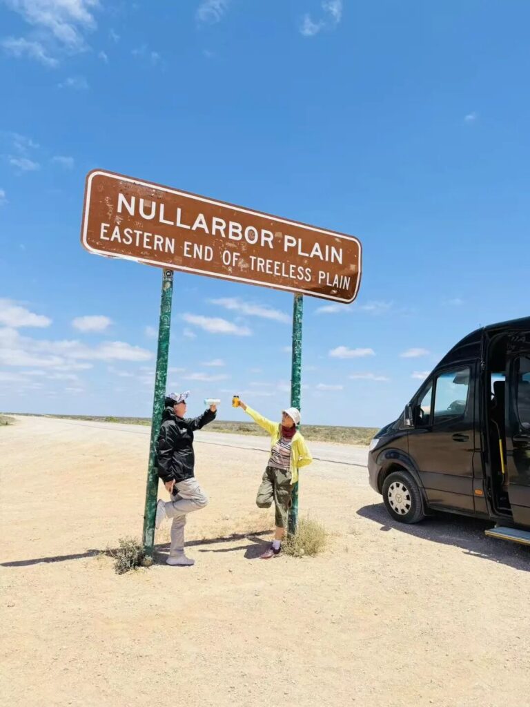 游客在Nullarbor Plain路牌下欢呼