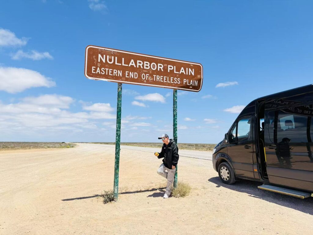 男士在Nullarbor Plain路牌下摆姿势