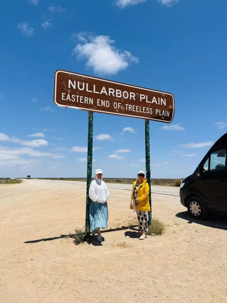 两位游客在Nullarbor Plain路牌下合影